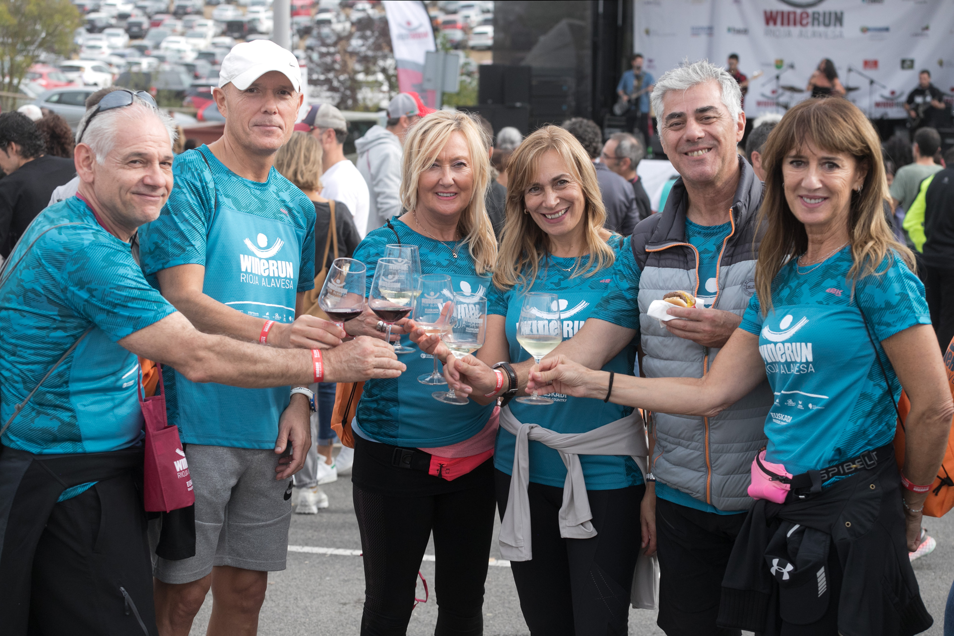 Grupo de personas con copas de vino en la mano, disfrutando de la feria